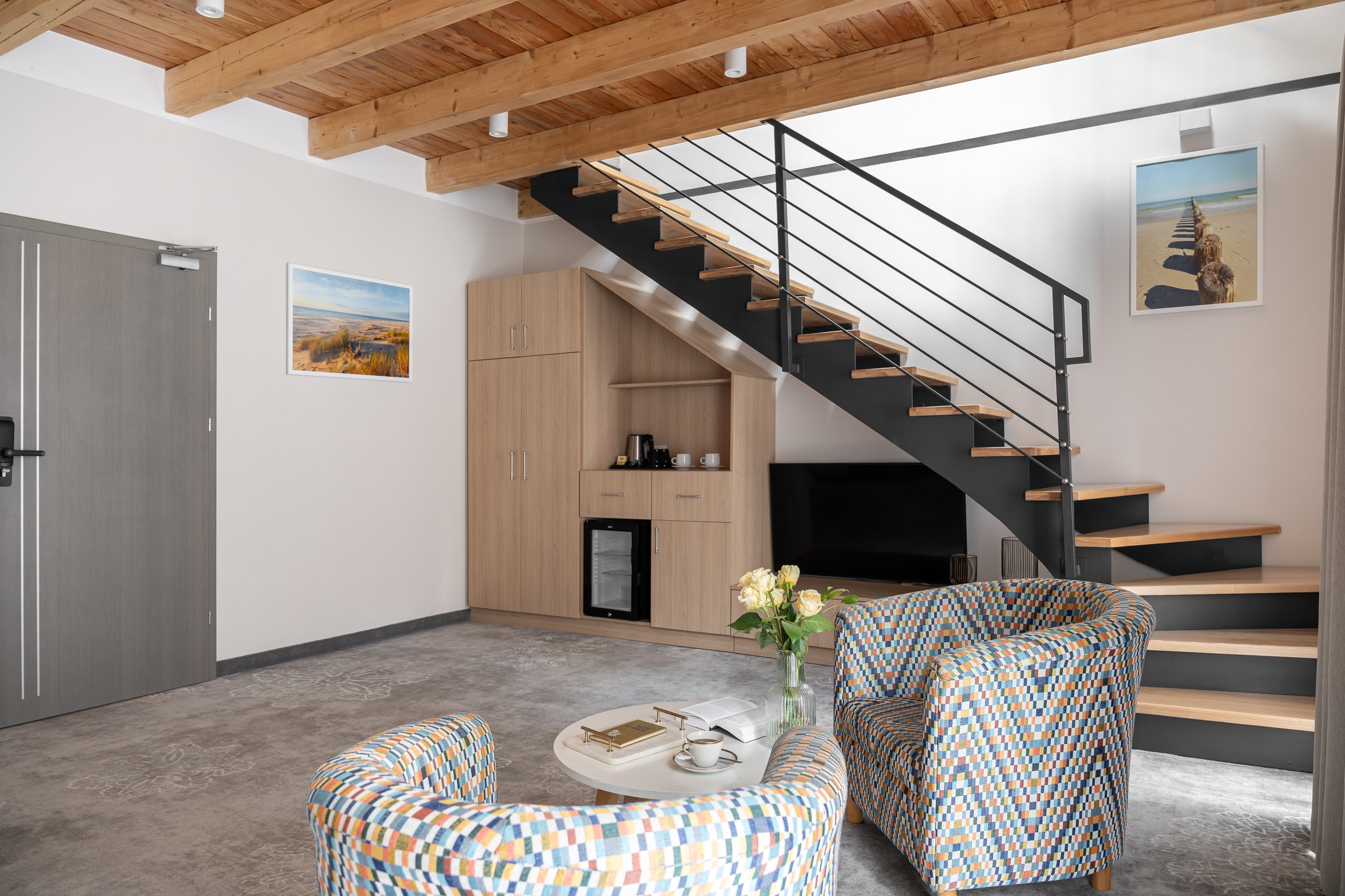 Apartment Maisonette Lux in der Residenz AMBRE in Łeba – Wohnzimmer mit Treppe, Sesseln und Fernseher
