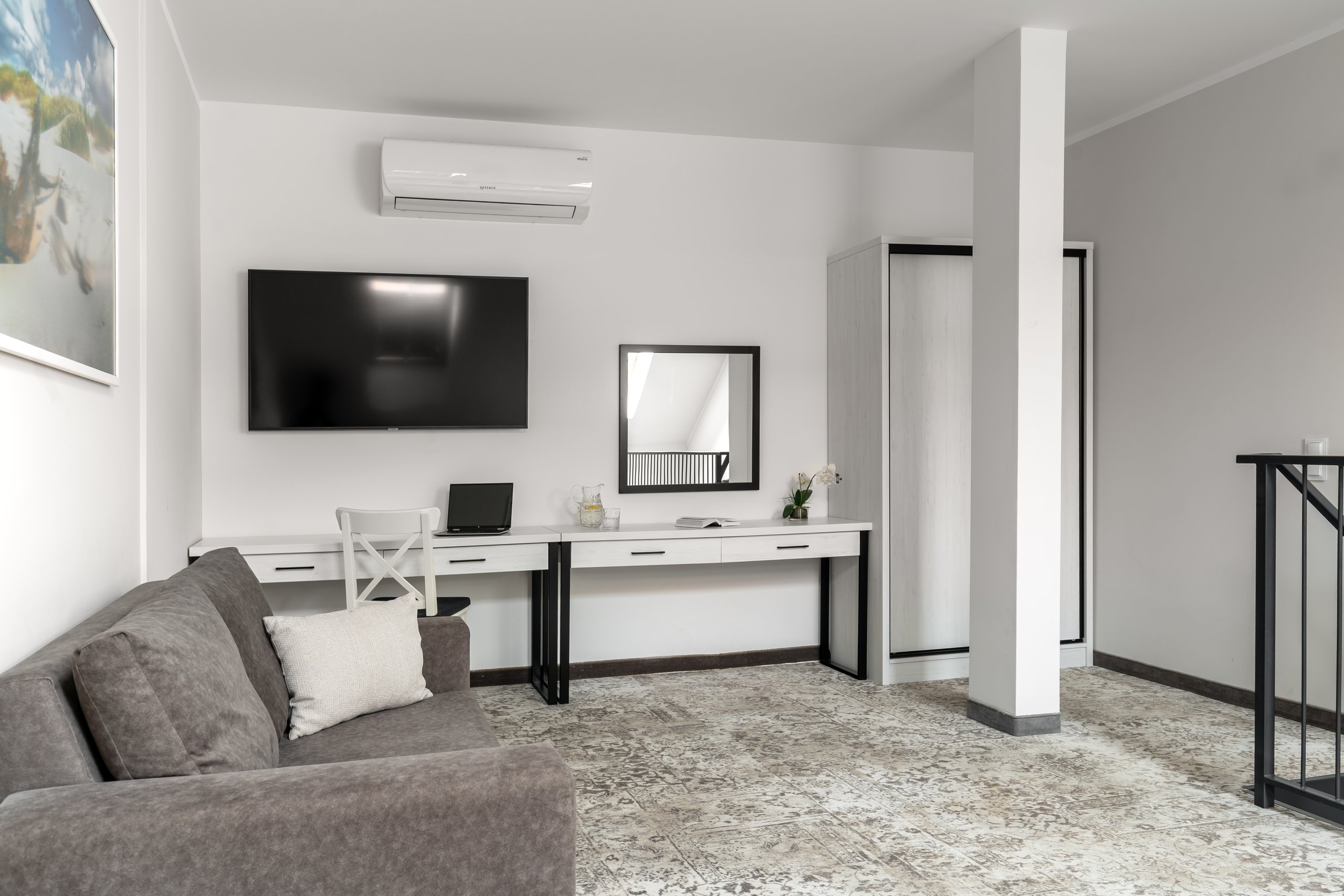 Apartment Maisonette Comfort Plus in der Residenz AMBRE in Łeba – Schreibtisch mit Spiegel, Fernseher und graues Sofa auf der Empore