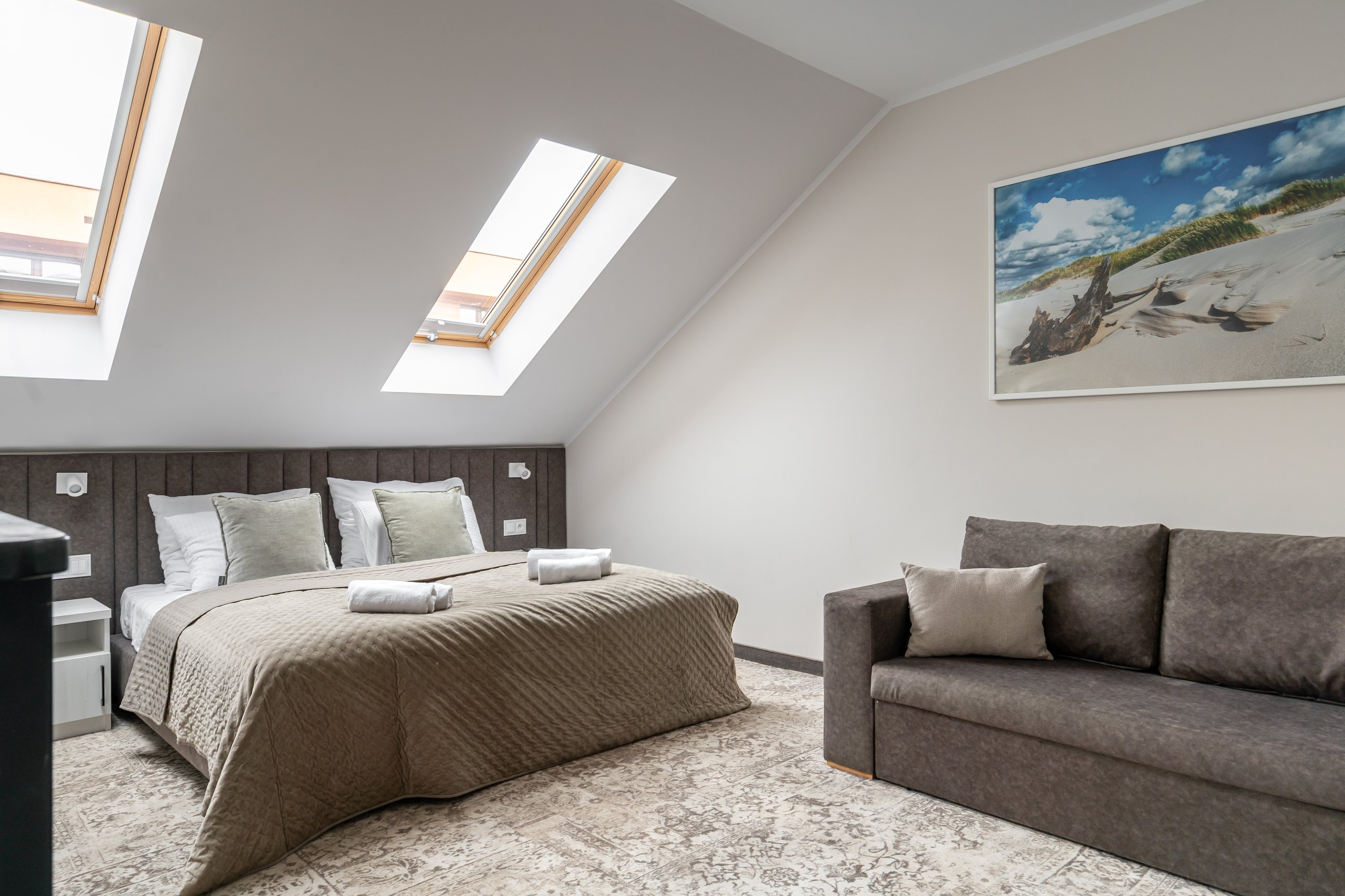 Apartment Maisonette Comfort Plus in der Residenz AMBRE in Łeba – Schlafzimmer im Dachgeschoss mit Bett und Sofa