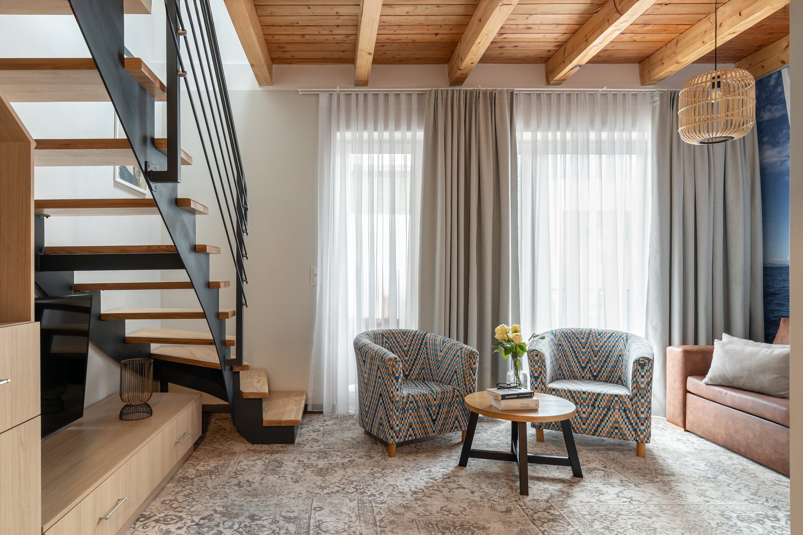 Apartment Maisonette Comfort Plus in der Residenz AMBRE in Łeba – Wohnzimmer mit Treppe zum Mezzanin und Holzbalkendecke.
