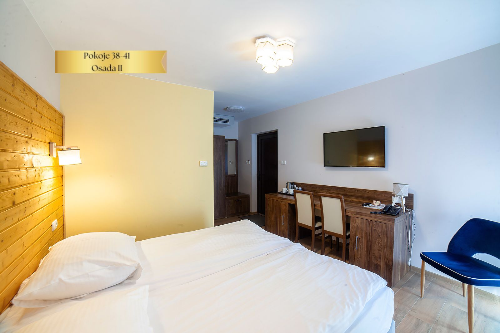 Pokój Comfort Plus w Osadzie II – łóżko, biurko i telewizor