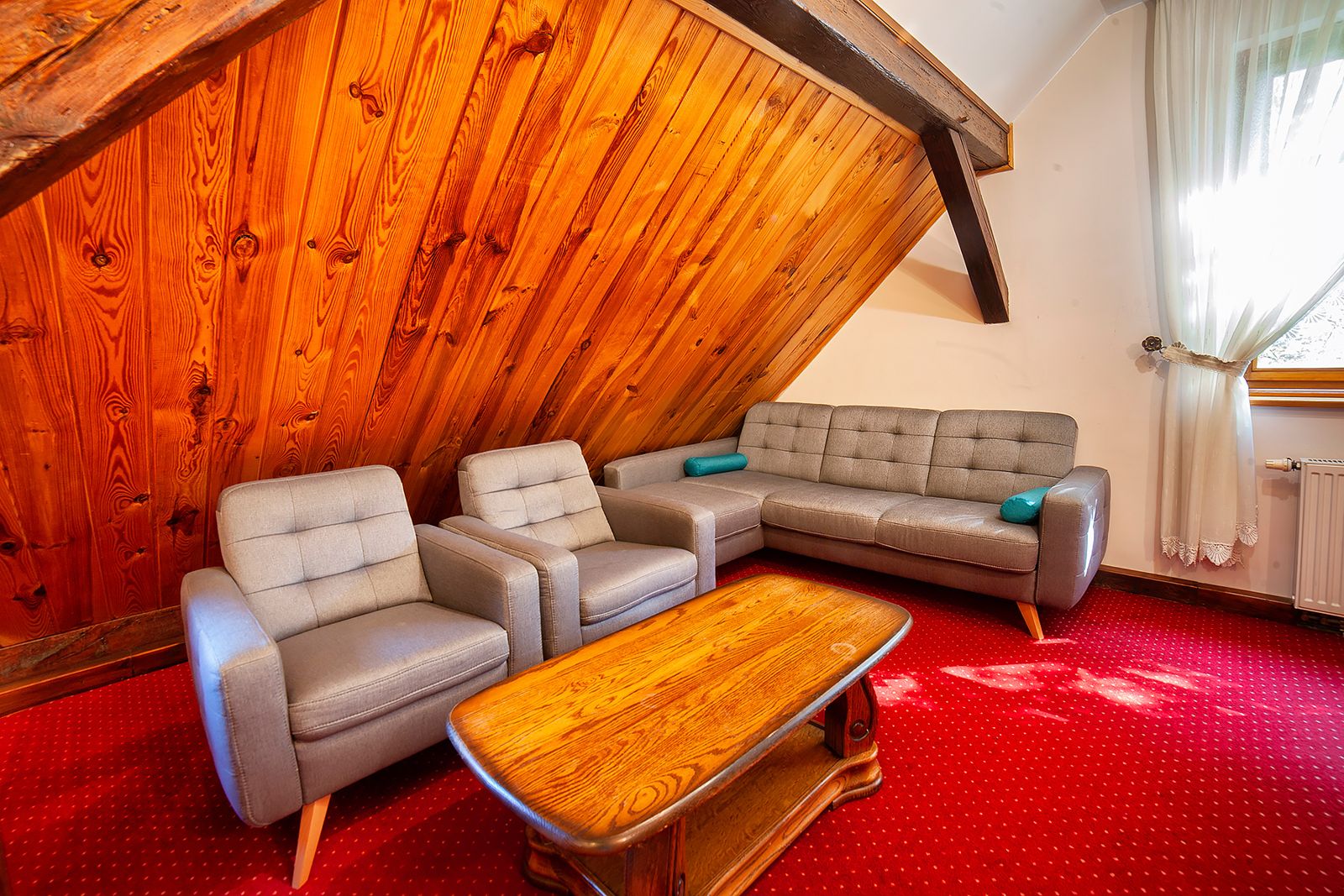 Studio 14 w Dworku Wapionka – salon z kanapą, fotelami i drewnianym stolikiem