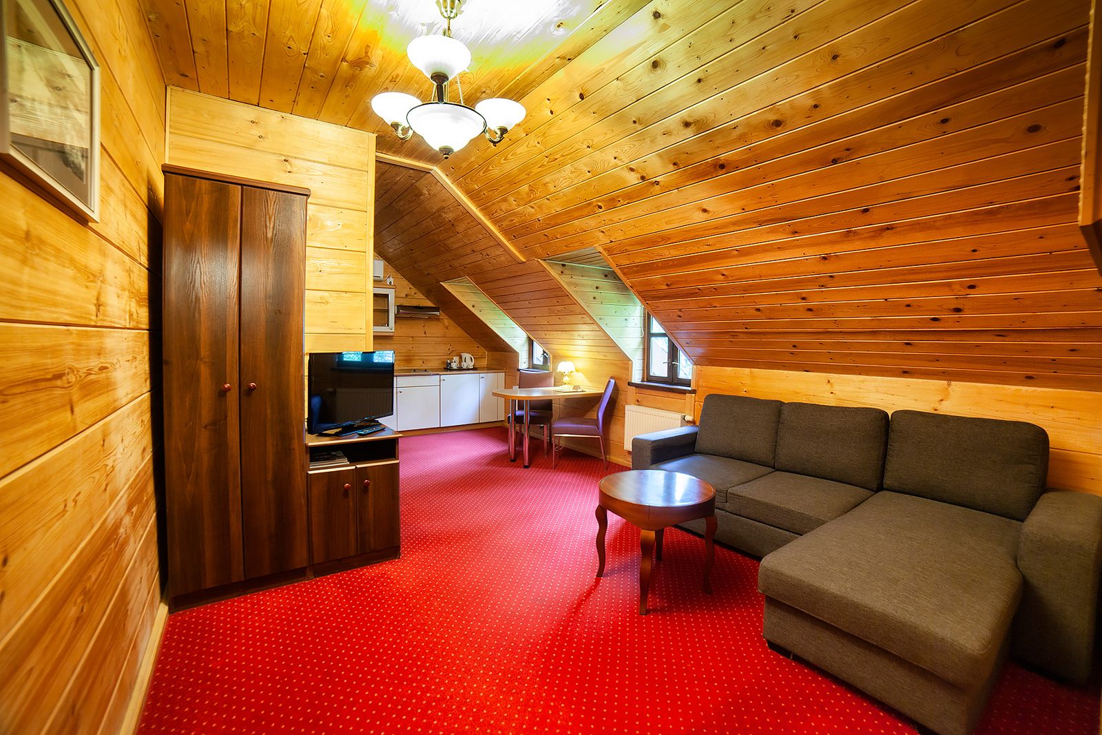Studio 21 w Dworku Wapionka – salon na poddaszu z narożną kanapą