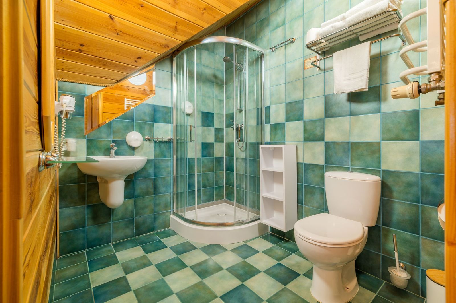 Bathroom in the Superior Studio with a shower enclosure and green tiles.