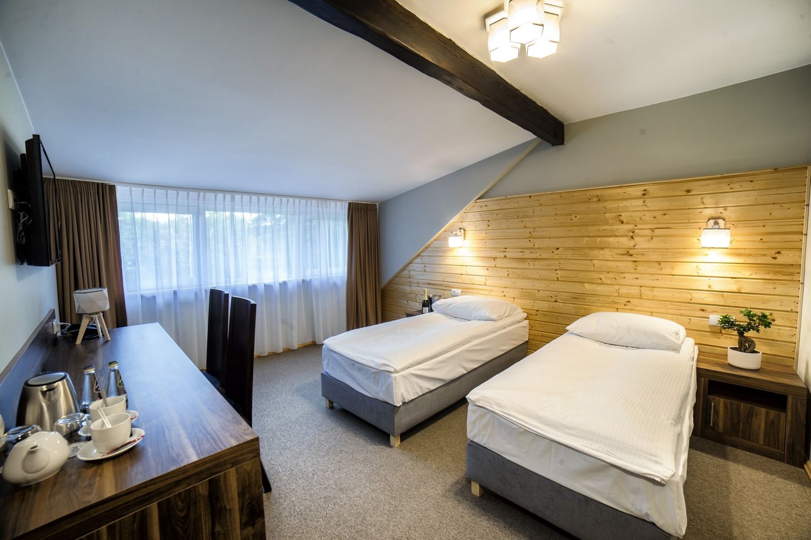 Pokój Comfort Superior w Dworku Wapionka – dwa łóżka i biurko z zestawem do kawy