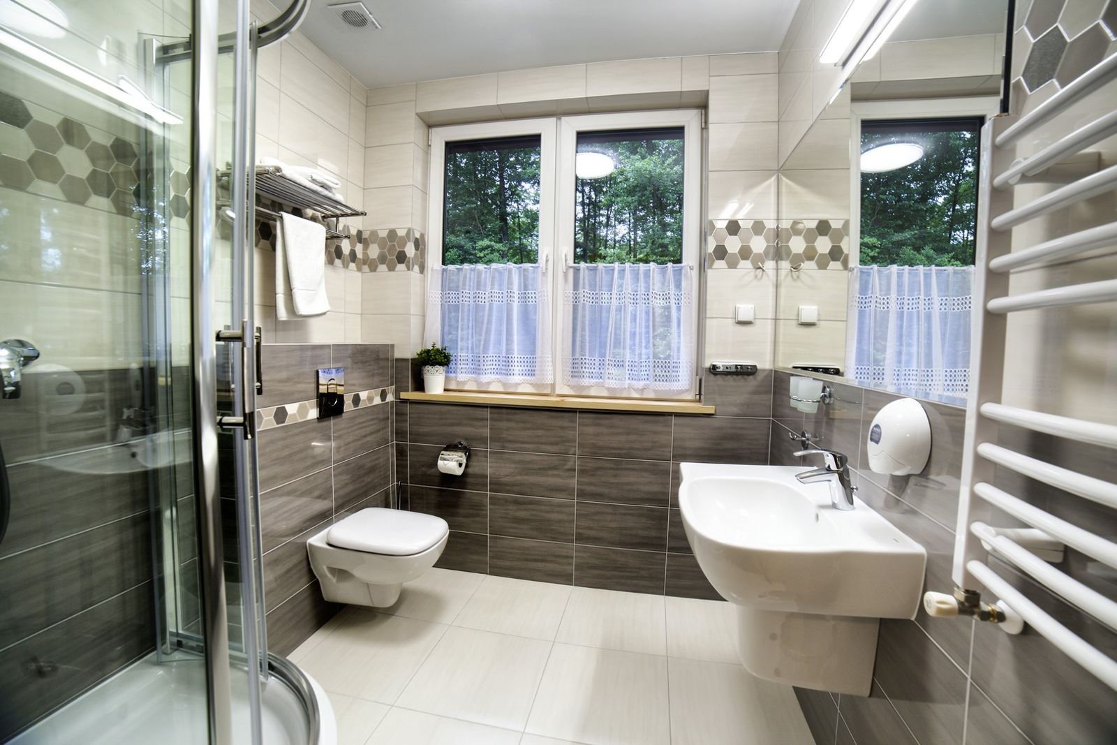 Bathroom with a shower and a window in the Comfort Superior room.
