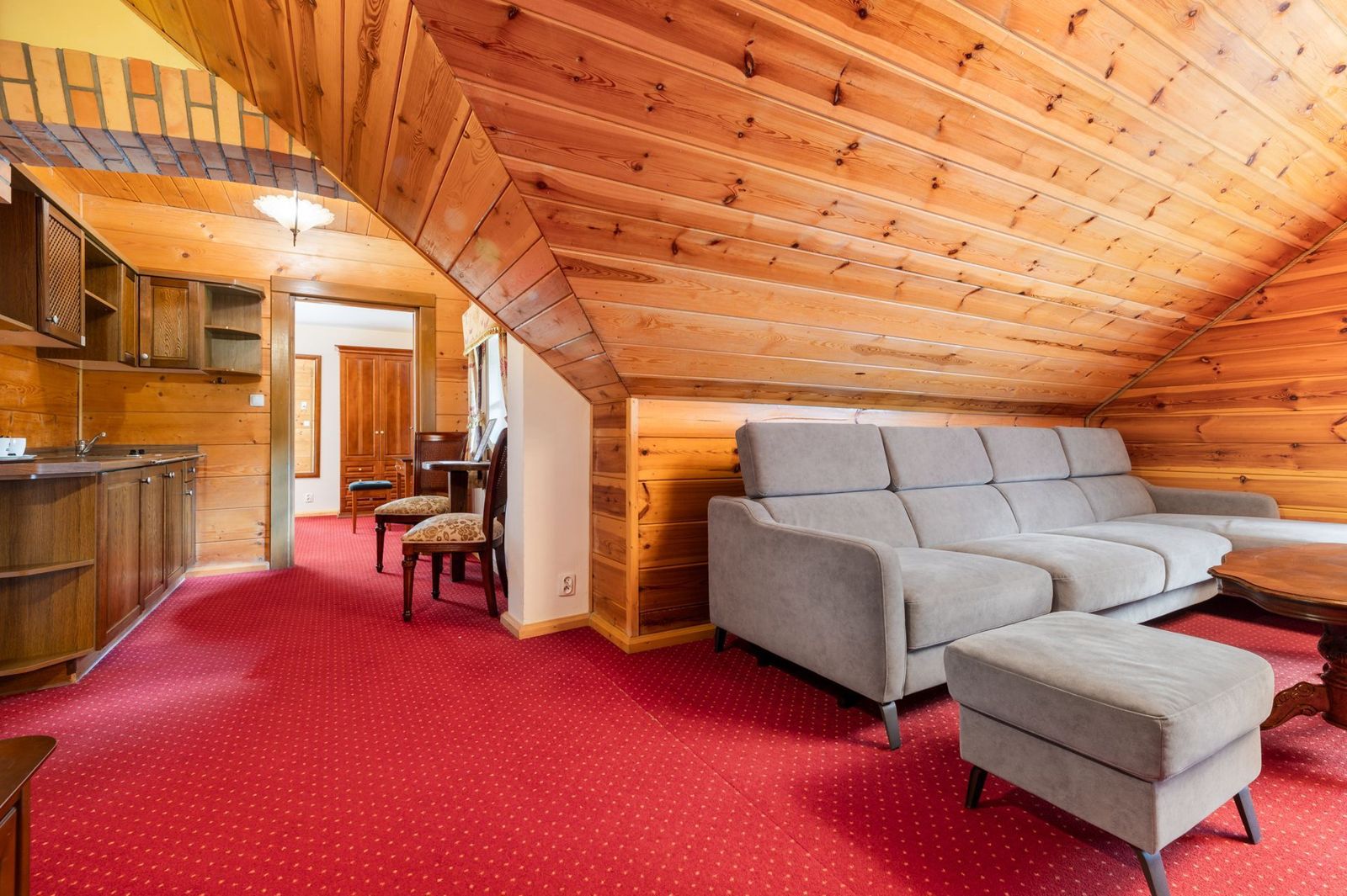 Superior Studio – living room with a sofa and a kitchenette in the background.