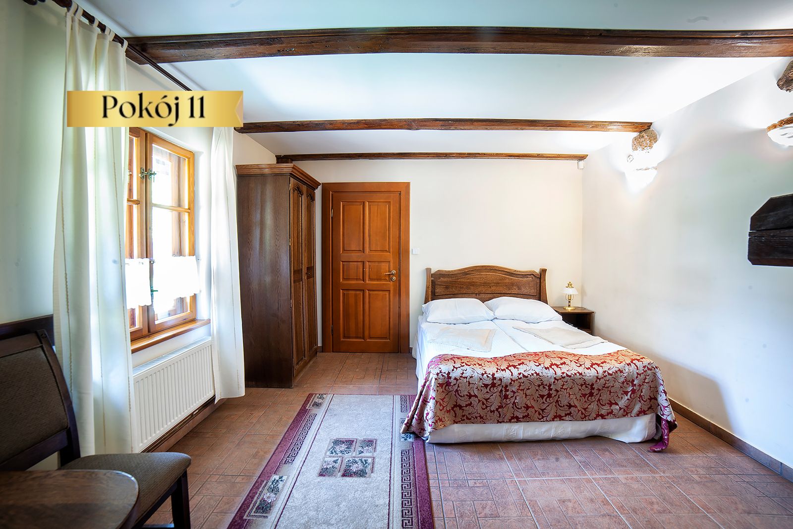 Pokój Standard Lux nr 11 – łóżko z narzutą i szafa