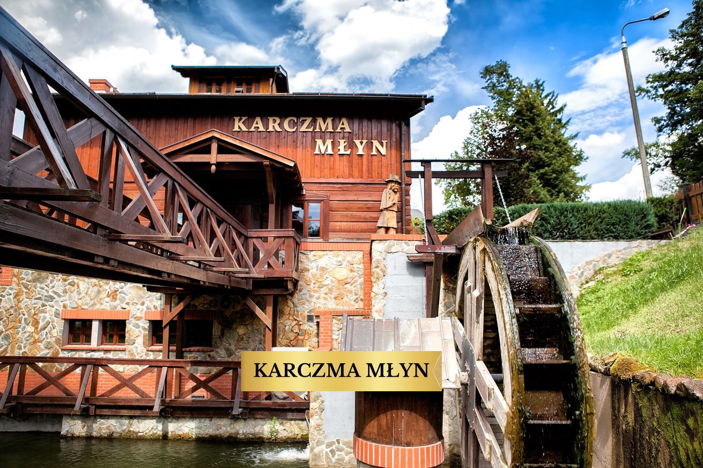 Karczma Młyn w Dworku Wapionka – drewniany budynek z kołem młyńskim