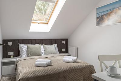 Apartment Maisonette Lux in der Residenz AMBRE in Łeba – Schlafzimmer im Dachgeschoss mit Doppelbett und Dachfenster