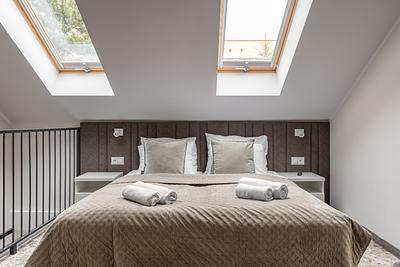 Apartment Maisonette Comfort Plus in der Residenz AMBRE in Łeba – Bett unter zwei Dachfenstern