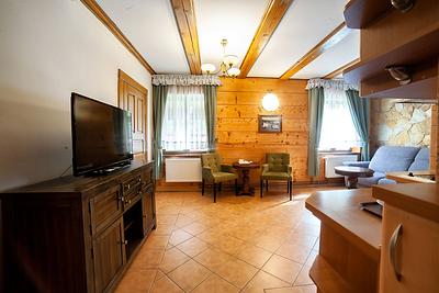 Studio 16 – salon z telewizorem i drewnianym sufitem