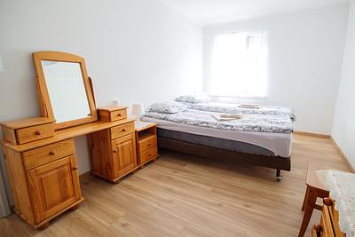 A room with a double bed and a wooden dressing table at Hajduczek.