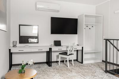 Apartment Maisonette Comfort in der Residenz AMBRE in Łeba – ein weißer Schreibtisch mit Spiegel, ein Fernseher und eine offene Garderobe.