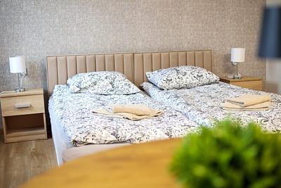 Beds with upholstered headboards and bedside lamps in a room at Hajduczek