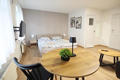 Round table with chairs and a bed in a room at Hajduczek