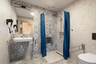Barrierefreies Badezimmer in der Residenz AMBRE in Łeba mit ebenerdiger Dusche und Haltegriffen.