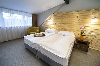 Pokój Comfort Superior – zsunięte łóżka i fotel przy oknie