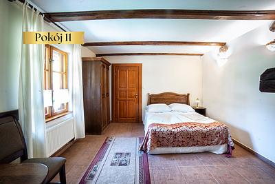 Pokój Standard Lux nr 11 – łóżko z narzutą i szafa