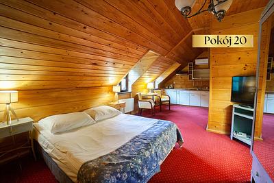 Pokój Standard Plus nr 20 na poddaszu – łóżko, telewizor i czerwona wykładzina