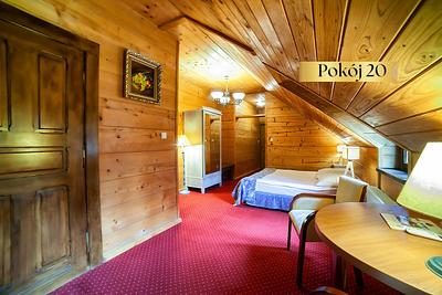 Pokój Standard Plus nr 20 pod skosem – drewniana boazeria i łóżko w głębi